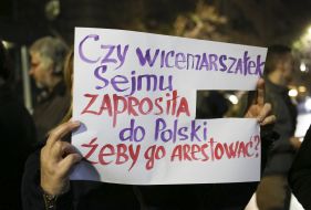 The activist holds a poster with the inscription in Polish