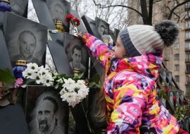 The girl lays flowers at the memorial Wall in the alley of Heroes Heavenly Hundreds