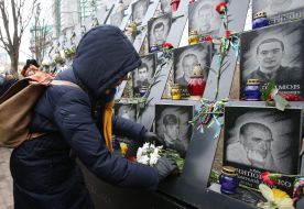 Participants of the prayer service lay flowers in photographs of Heavenly Hundred Heroes
