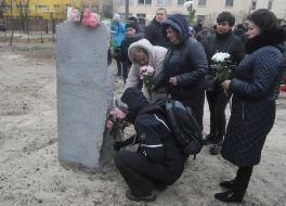 Люди кладут цветы к Памятному знаку в честь защитников Украины