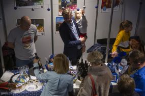 The girl in the hands of a man contemplates Christmas decorations