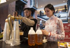 The seller pours beer into bottles