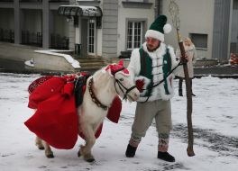 Помічник Святого Миколая веде поні