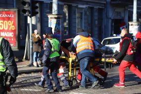 Сотрудники полиции и скорой помощи везут женщину на носилках