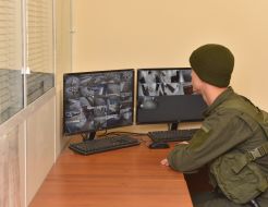 Правоохранитель наблюдает за изображением на мониторах