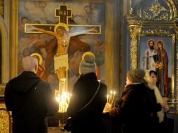 Люди ставят свечи в Михайловском Златоверхом соборе