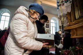 Женщина держит книгу «Капелланы. На службе Богу и Украине»