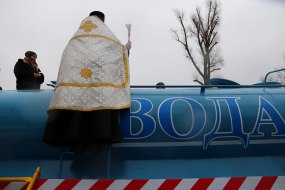 Священник освящает цистерну с питьевой водой
