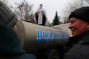 Священник освящает цистерну с питьевой водой