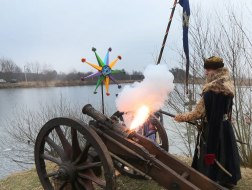 Reconstruction participant in a historical costume shoots a gun