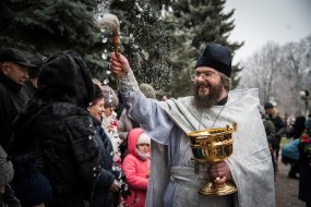 The priest sprinkles the believers with holy water