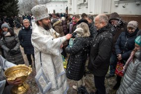 The priest sprinkles the believers with holy water