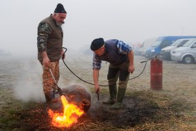 Мясники обжигают тушу свиньи