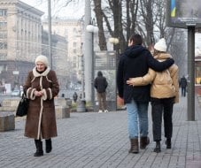 Літня жінка та молода пара