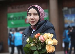 The participant of the action holds flowers