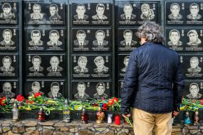A man with flowers near the memorial