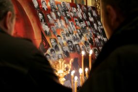 Candles on the background of a poster with photos of Heroes of Heavenly Hundred