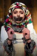 A girl in a Ukrainian suit in handcuffs and with a taped mouth