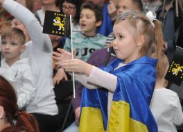 Девочка с флагом Украины на плечах и флажком с надписью Харьков в руках