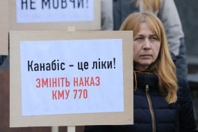 Участница акции держит плакат с надписью "Каннабис - это лекарство!"