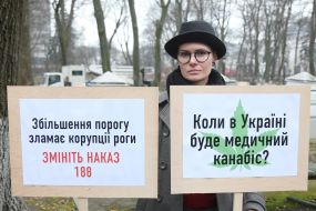 Участница акции держит плакаты