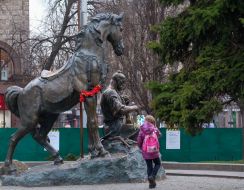 The girl passes by the monument to Cossack Mamay