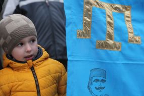 The boy at the flag of the Crimean Tatars