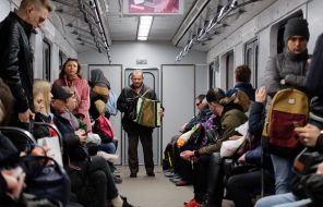 A man plays on the accordion in a subway car