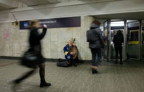 Мужчина в национальном украинском костюме играет на бандуре в подземном переходе