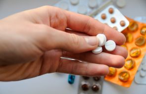 Woman holds pills in her hand