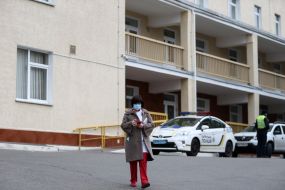 Girl in medical mask is  talking on a cell phone.