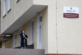 Girl in medical mask is  talking on a cell phone.