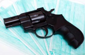 The revolver rests on medical masks