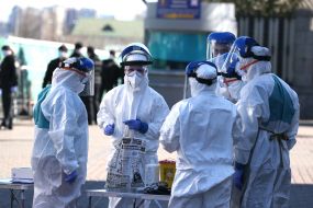 Специалисты в защитных  костюмах