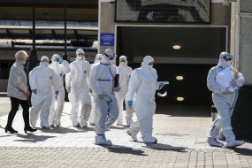 Специалисты в защитных  костюмах