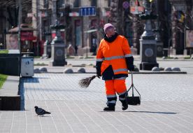 Работница коммунального хозяйства убирает на улице