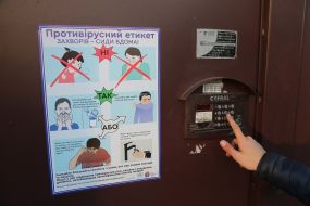 Poster labeled "Social Etiquette" on the door of a residential building during quarantine