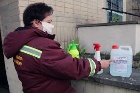 A utility worker shows disinfectant solutions