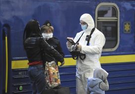 Border guards in a protective suit checks the documents