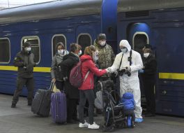 Border guards in a protective suit checks the documents