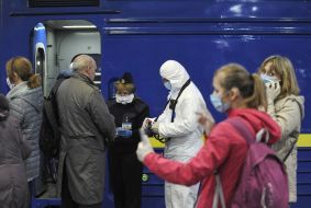 Border guards in a protective suit checks the documents
