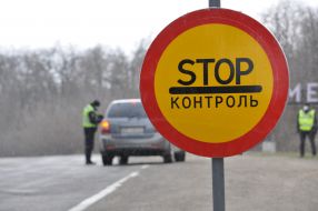 Stop control road sign near police checkpoint together with National Guard at Khmelnitsky entrance