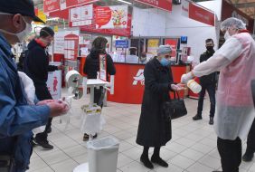An elderly masked woman disinfects her hands at the Auchan hypermarket in Zaporozhye
