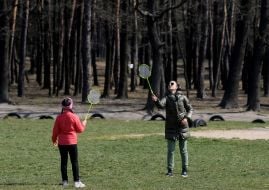 Woman with girl playing badminton in the park
