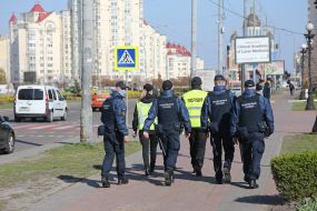 Law enforcement officers together with National Guard troops patrol the street