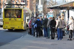 Люди стоят в очереди на остановке общественного траспорта