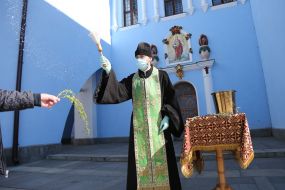 The clergyman sprinkles a willow branch with holy water