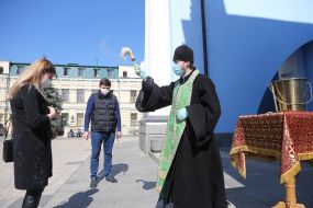 The clergyman sprinkles the parishioner with holy water