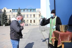 The clergyman sprinkles the parishioner with holy water