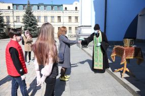 The clergyman gives the consecrated branches of the willow to the parishioners